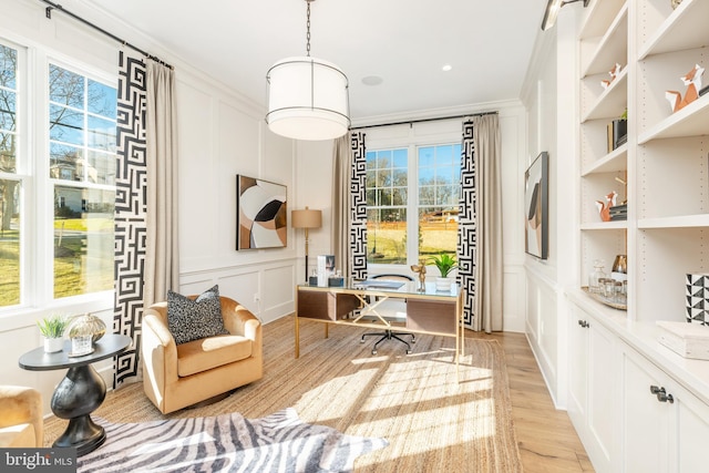 sitting room with light hardwood / wood-style flooring and crown molding