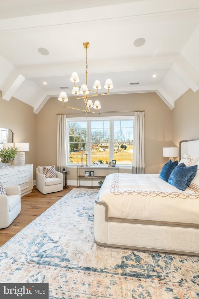 bedroom featuring hardwood / wood-style floors, lofted ceiling, and an inviting chandelier