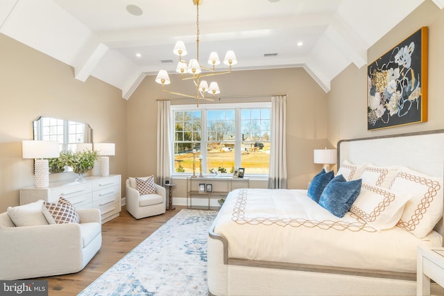 bedroom featuring a notable chandelier, light wood-type flooring, and vaulted ceiling