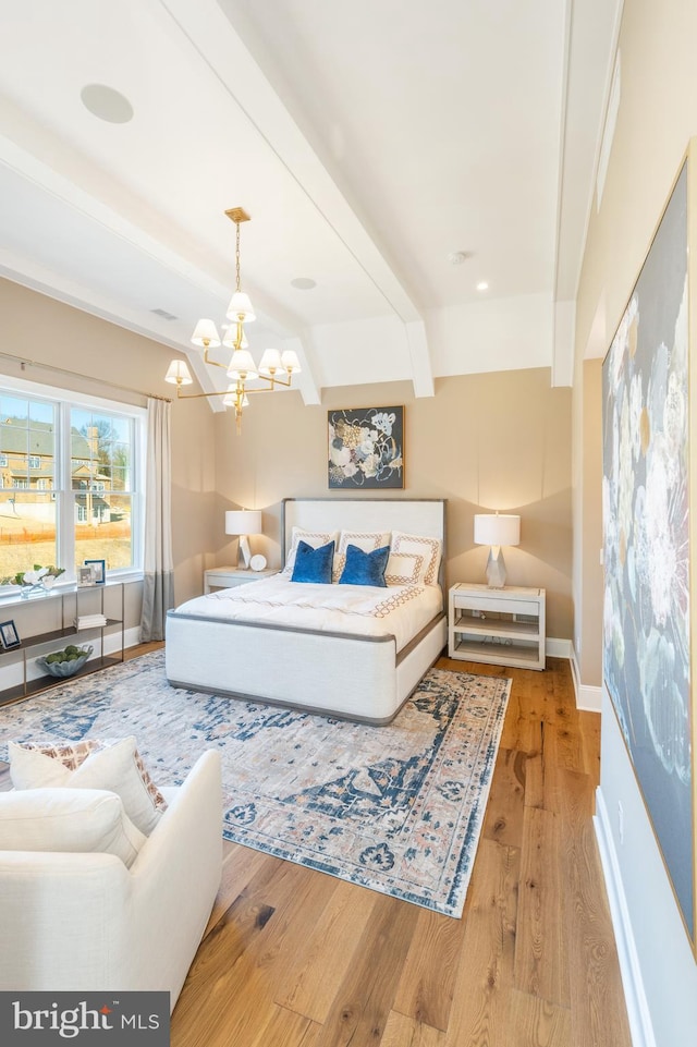 bedroom with beam ceiling, a chandelier, and light wood-type flooring