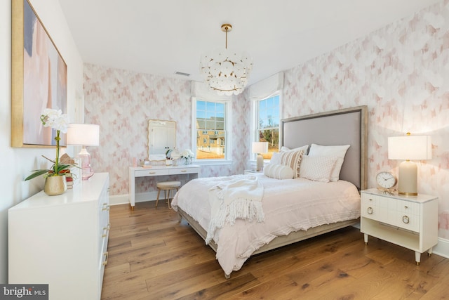 bedroom with hardwood / wood-style flooring and a notable chandelier