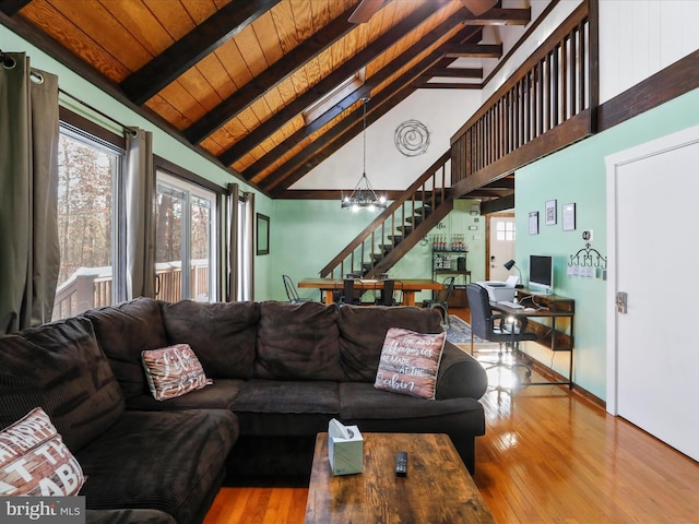 living room featuring high vaulted ceiling, light hardwood / wood-style flooring, a notable chandelier, beam ceiling, and wood ceiling