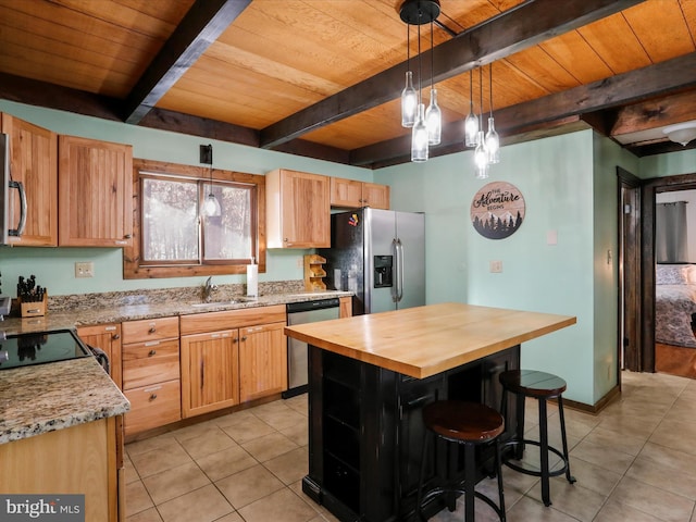 kitchen featuring beamed ceiling, a center island, appliances with stainless steel finishes, and pendant lighting