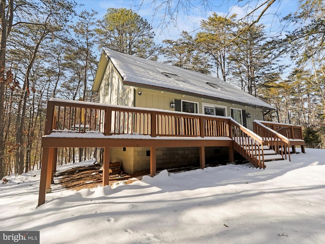 snow covered house featuring a deck