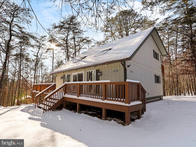 snow covered house with a wooden deck