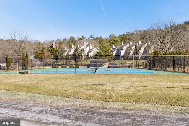 view of tennis court featuring a lawn