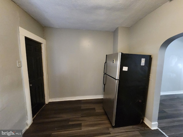 kitchen with stainless steel fridge, dark hardwood / wood-style flooring, and a textured ceiling