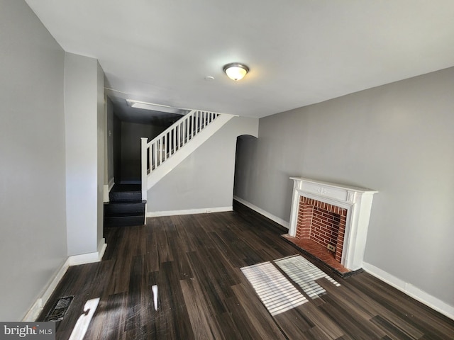 unfurnished living room featuring a fireplace and dark hardwood / wood-style floors