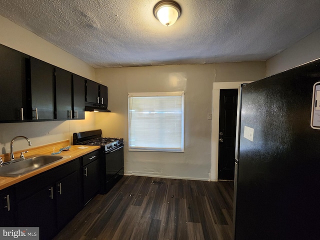 kitchen featuring black gas range, dark hardwood / wood-style flooring, sink, and a textured ceiling