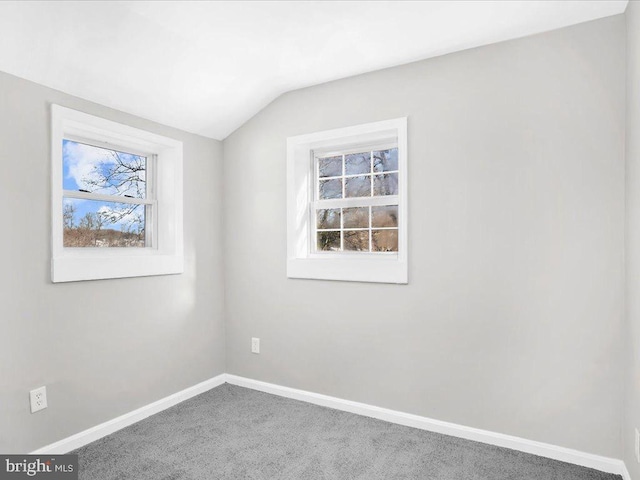 empty room featuring carpet flooring and vaulted ceiling