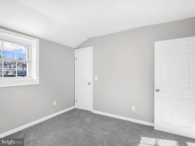 empty room with carpet flooring and lofted ceiling