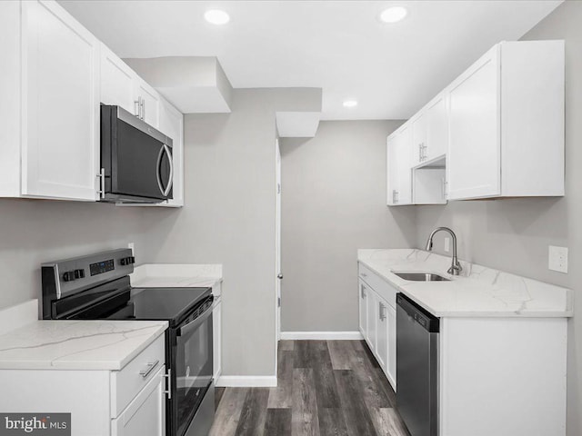 kitchen featuring white cabinetry, sink, stainless steel appliances, light stone counters, and dark hardwood / wood-style floors