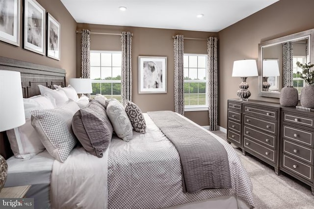 bedroom with light colored carpet and multiple windows