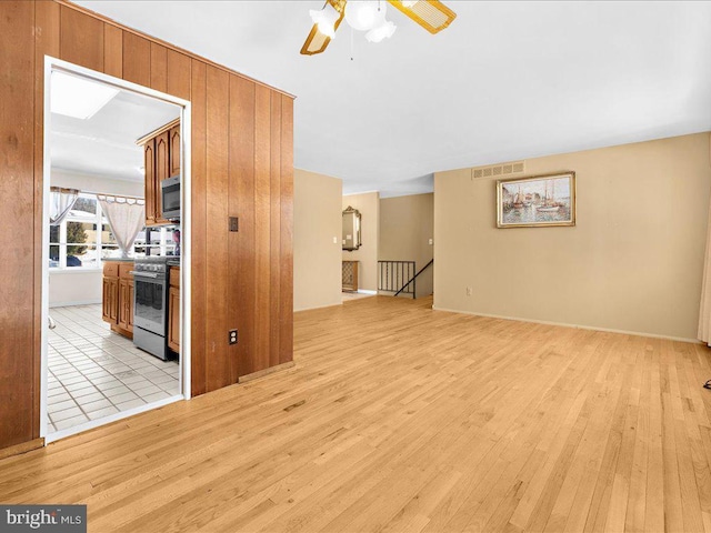 unfurnished living room featuring ceiling fan and light wood-type flooring