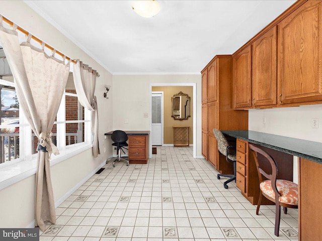 office with built in desk and ornamental molding