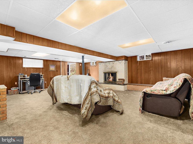 carpeted living room with wood walls and a brick fireplace