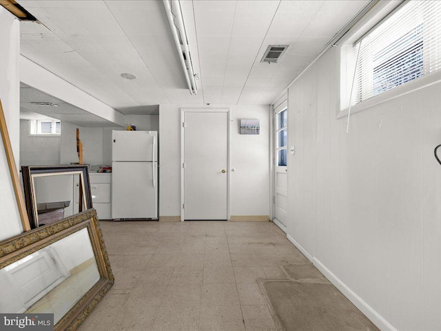 basement with white refrigerator and washer / clothes dryer