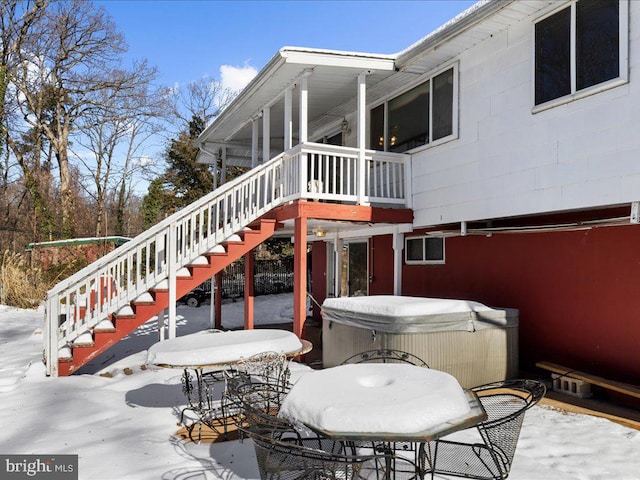 snow covered deck featuring a hot tub