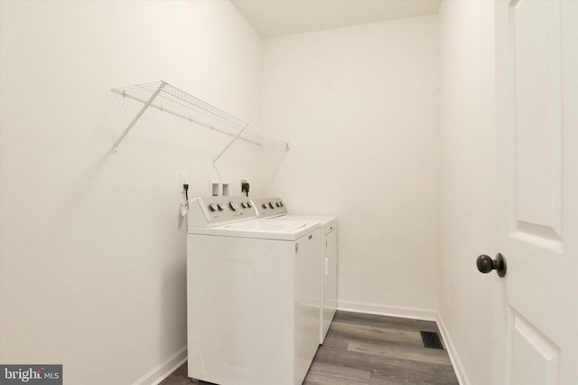 laundry area with dark hardwood / wood-style floors and independent washer and dryer