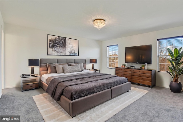 carpeted bedroom featuring a notable chandelier