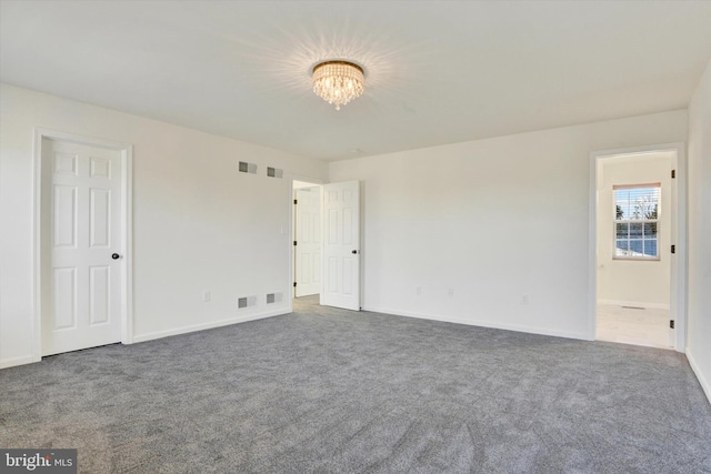 empty room featuring carpet and an inviting chandelier