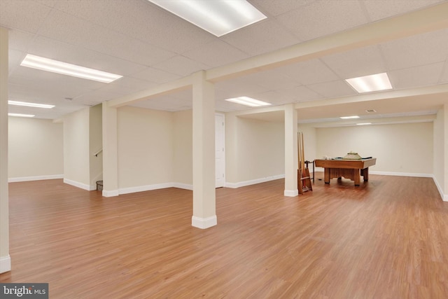 basement featuring a paneled ceiling and wood-type flooring