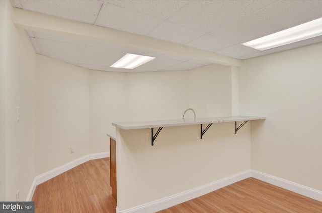 interior space with hardwood / wood-style flooring and a drop ceiling