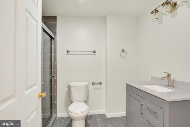 bathroom with vanity, toilet, and a shower with shower door