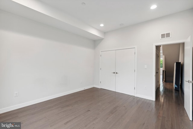 unfurnished bedroom featuring a closet and dark wood-type flooring