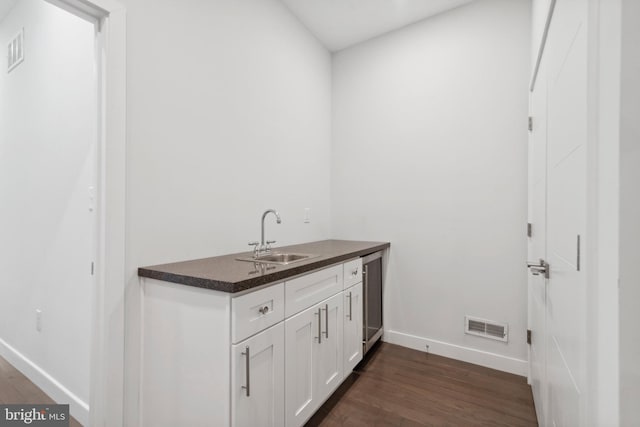 interior space featuring dark hardwood / wood-style floors, white cabinetry, and sink