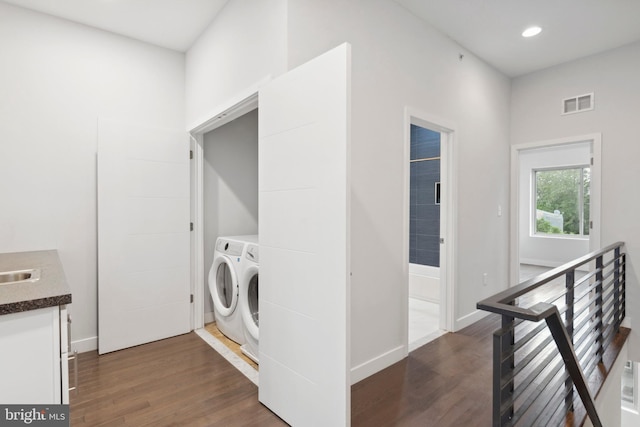 clothes washing area featuring washer and dryer and dark hardwood / wood-style floors