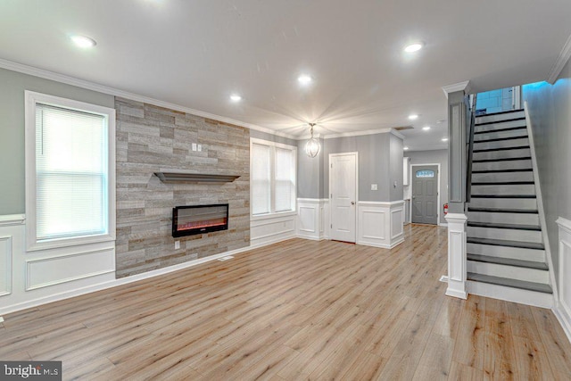 unfurnished living room with a tile fireplace, light hardwood / wood-style floors, and crown molding