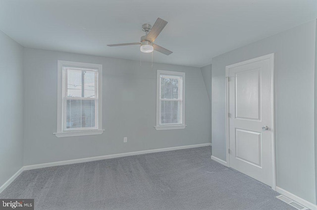 carpeted spare room with ceiling fan