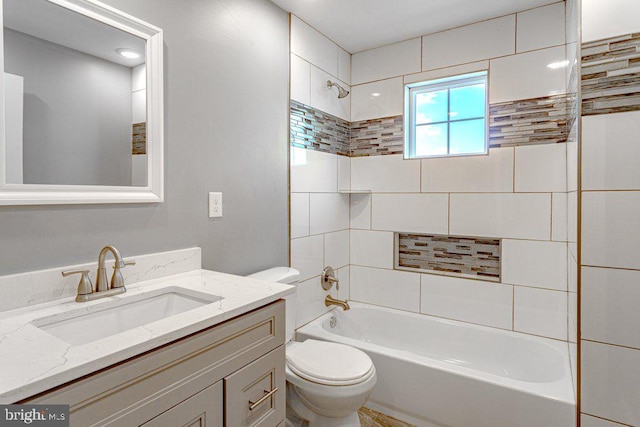 full bathroom with vanity, tiled shower / bath combo, and toilet