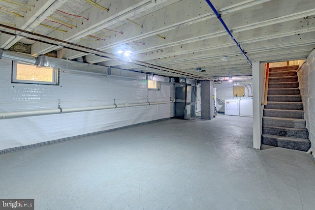 basement featuring washing machine and dryer and heating unit