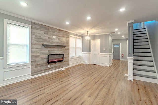 unfurnished living room with a tile fireplace, a healthy amount of sunlight, light hardwood / wood-style floors, and crown molding