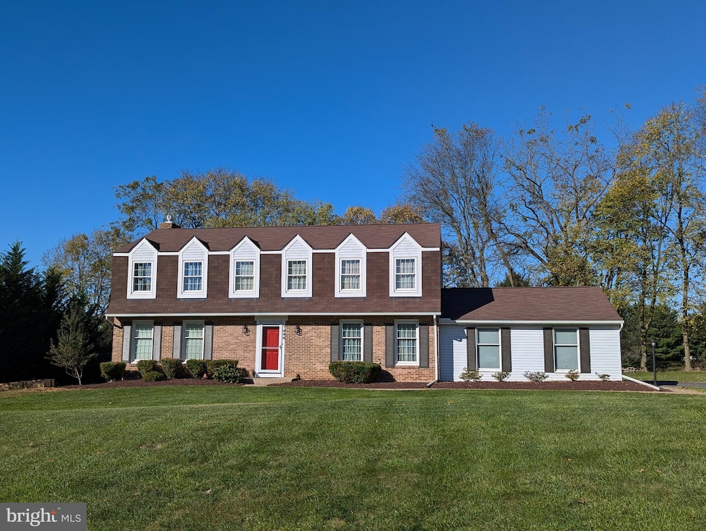 cape cod house with a front yard