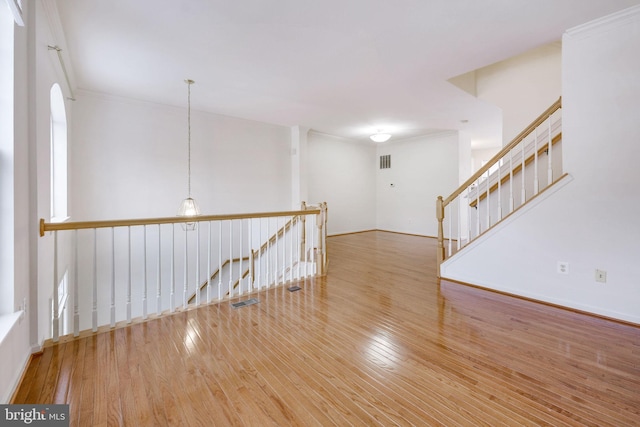 spare room with crown molding and hardwood / wood-style floors