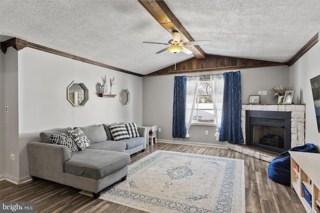 living room featuring hardwood / wood-style flooring, ceiling fan, a fireplace, and a textured ceiling