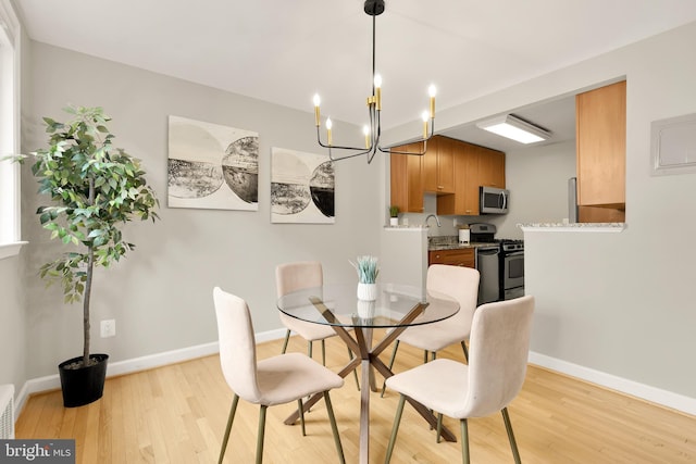 dining room with light wood-type flooring and an inviting chandelier