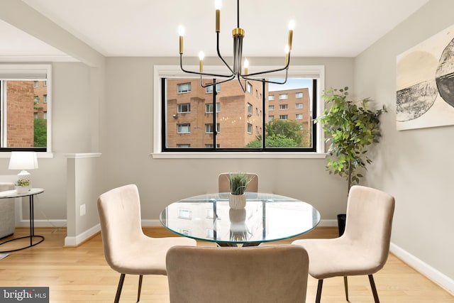 dining room with light wood-type flooring and a chandelier