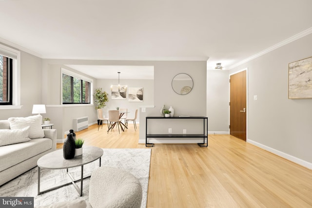 living room with crown molding, a notable chandelier, and hardwood / wood-style flooring