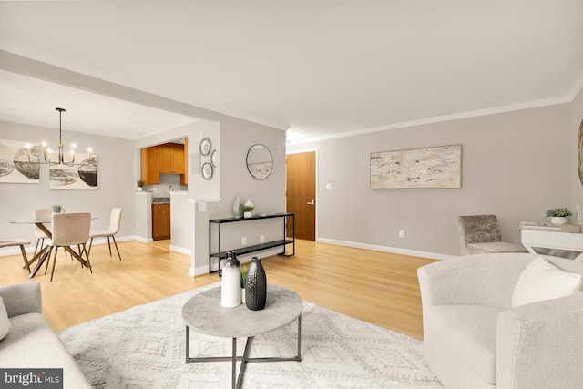 living room with light wood-type flooring, crown molding, and an inviting chandelier