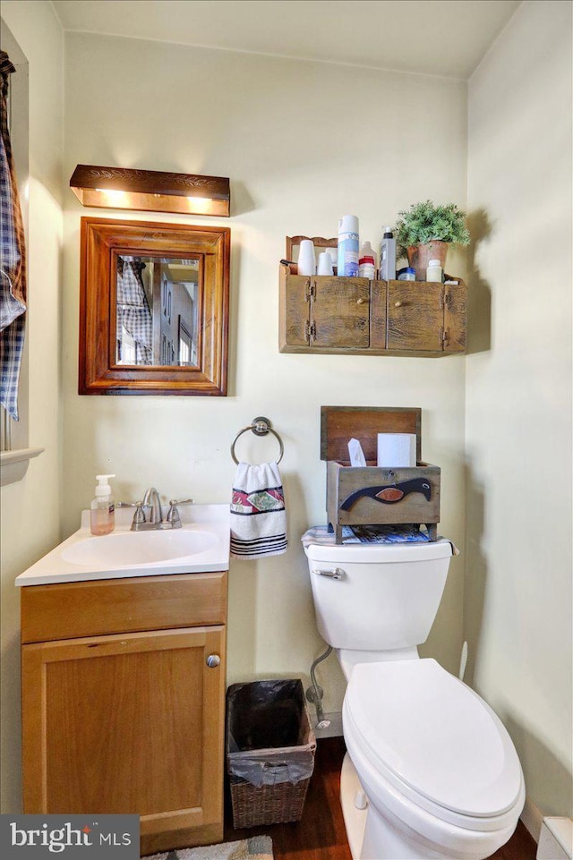 bathroom featuring hardwood / wood-style flooring, vanity, and toilet