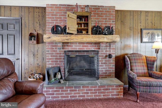 living room with carpet, a brick fireplace, and wooden walls