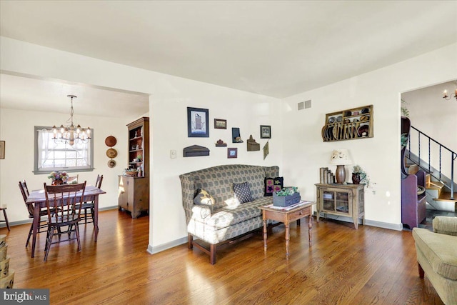 living room with hardwood / wood-style floors and an inviting chandelier