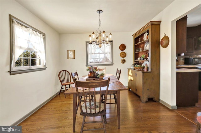 dining area featuring an inviting chandelier, plenty of natural light, and dark wood-type flooring