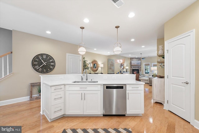 kitchen with a kitchen island with sink, sink, stainless steel dishwasher, and white cabinets