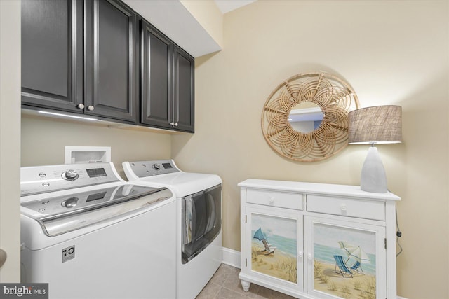 laundry area featuring cabinets, washing machine and clothes dryer, and light tile patterned flooring