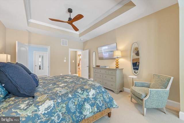 carpeted bedroom featuring ornamental molding, ceiling fan, and a tray ceiling